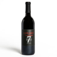 A bottle of conjure wine with red font and the number seven. The words listed are conjure, Word Wine Collection, and zinfandel.
