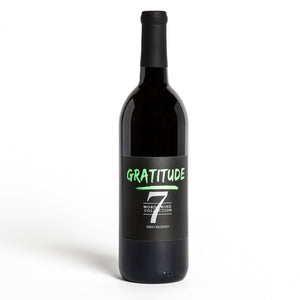 A bottle of gratitude wine with green font and the number seven. The words listed are gratitude, Word Wine Collection, and red blend.